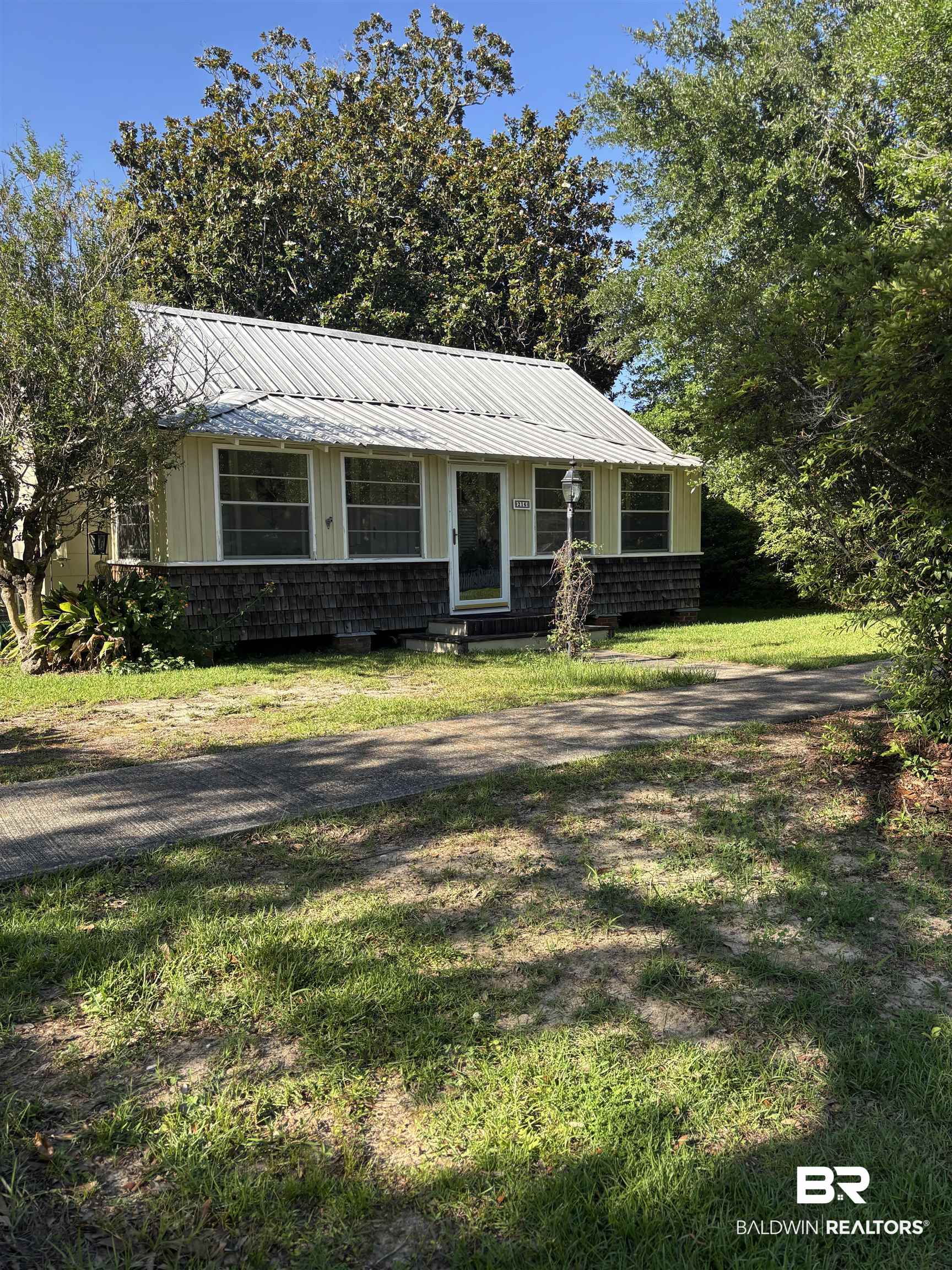 216 West Orange Avenue Foley, AL 36535 - Photo 2 of 37 View of front of house featuring metal roof and a front yard