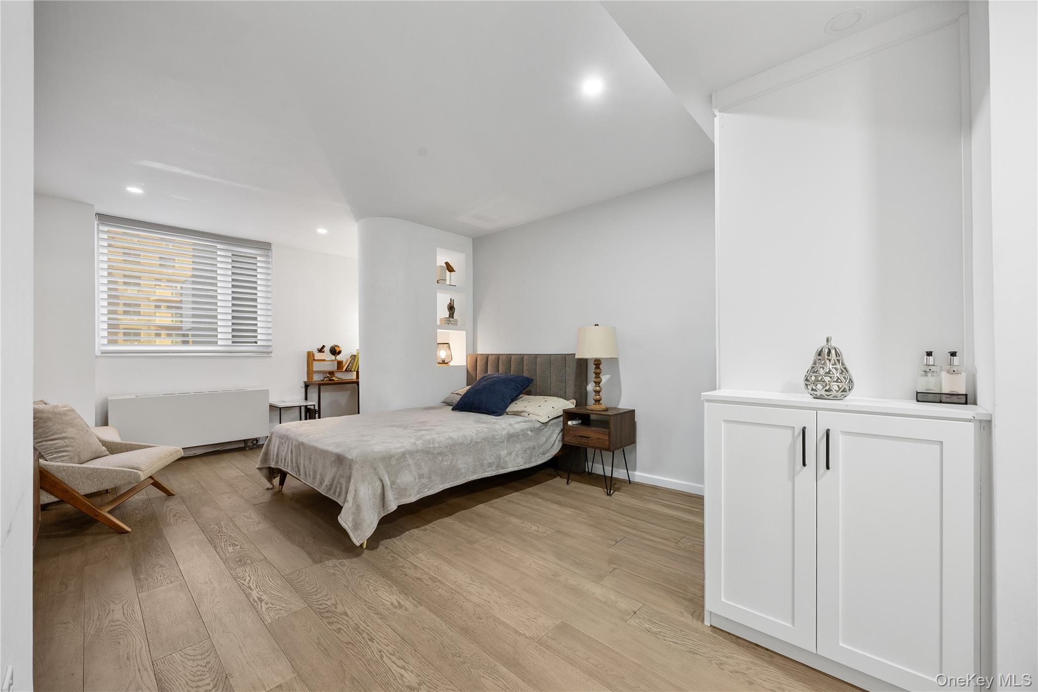 133-38 Sanford Avenue, Unit 6C Queens, NY 11355 - Photo 12 of 21 a bedroom with a bed and wooden floor