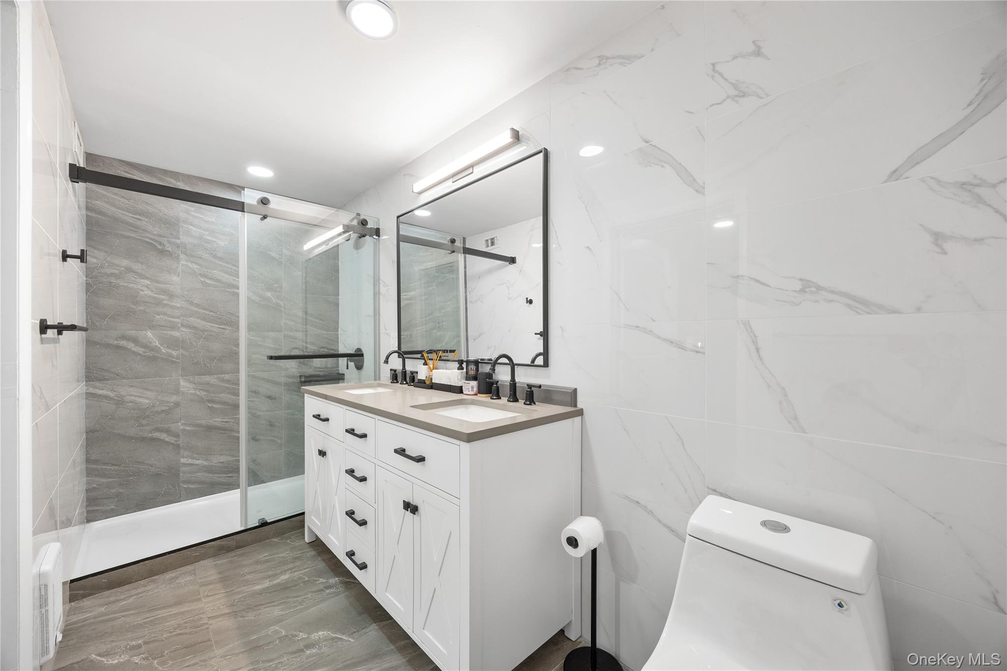 133-38 Sanford Avenue, Unit 6C Queens, NY 11355 - Photo 14 of 21 a bathroom with a double vanity sink toilet and shower