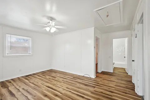 a view of a room with wooden floor and ceiling fan