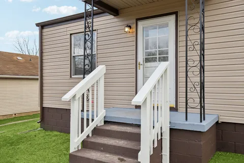 a view of a house with wooden stairs and a fence