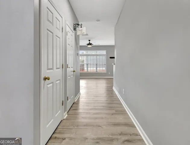 a view of a hallway with wooden floor and staircase
