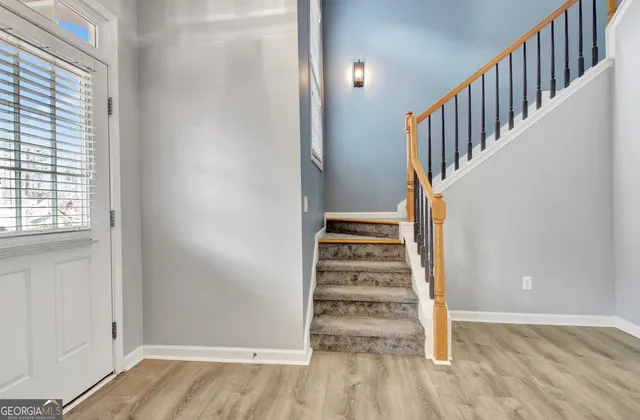 a view of a hallway with wooden floor and entryway