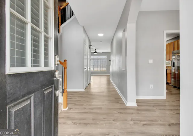 a view of a hallway with wooden floor and staircase