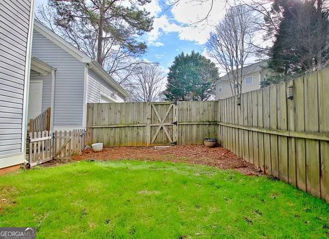 a view of a deck with a large window and wooden fence