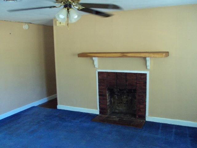 2068 Shockley Springs Road Baker, FL 32531 - Photo 3 of 5 a room with a fireplace and a ceiling fan