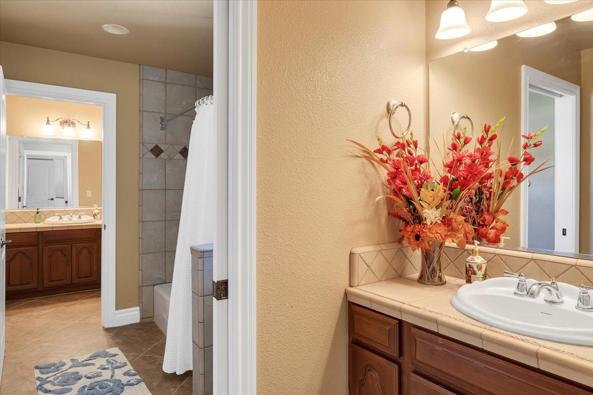 294 Sunrise Road, Unit 2 Copperopolis, CA 95228 - Photo 66 of 98 a bathroom with a granite countertop sink a mirror and a shower