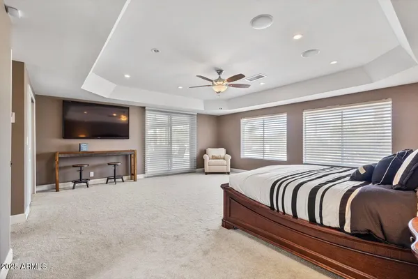 a spacious bedroom with a bed and a flat screen tv