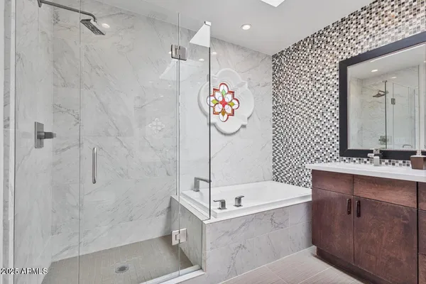 a bathroom with a tub a sink and a shower