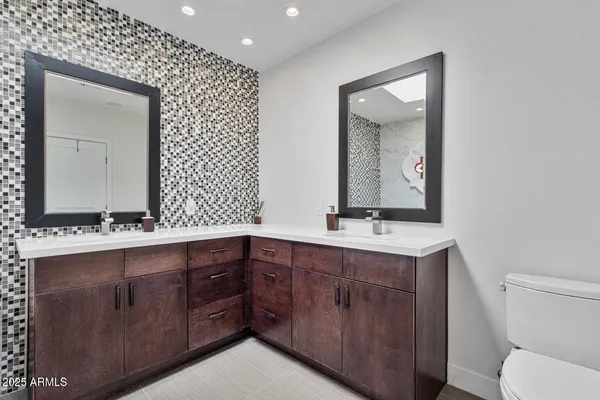 a bathroom with a toilet sink and mirror