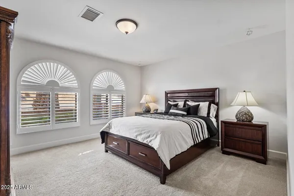 a spacious bedroom with a bed and a chandelier