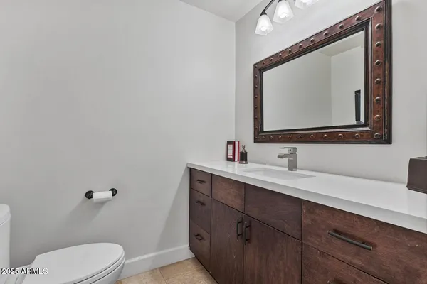 a bathroom with a toilet sink a mirror and vanity