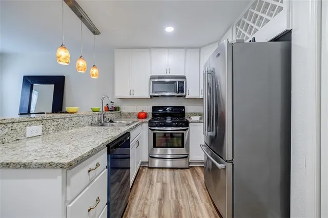 a kitchen with granite countertop a refrigerator and a sink