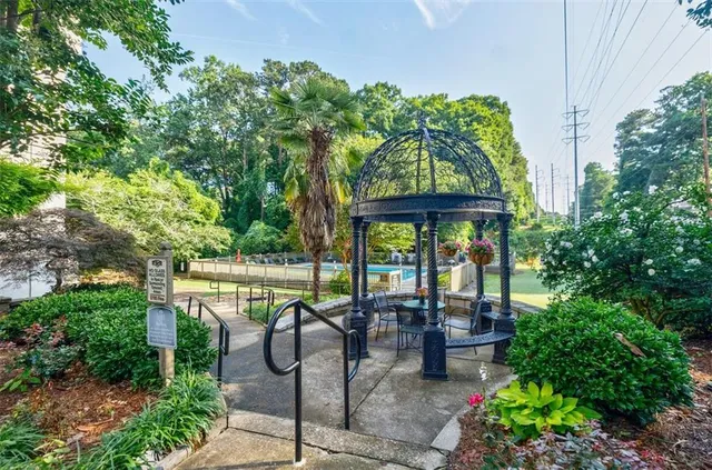 a view of a patio with table and chairs potted plants and floor to ceiling window