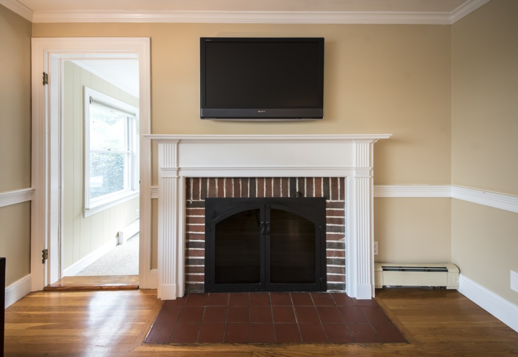 16 Latin Road Boston, MA 02132 - Photo 4 of 26 a living room with a fireplace and a flat screen tv