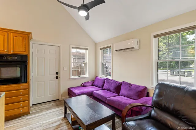 a living room with furniture a flat screen tv and a window