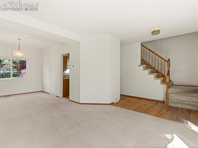 7590 Julynn Road Colorado Springs, CO 80919 - Photo 28 of 44 Empty room featuring hardwood / wood-style floors and a chandelier
