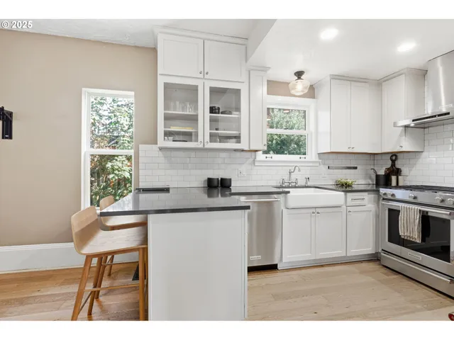 a kitchen with stainless steel appliances granite countertop a stove a sink and a microwave