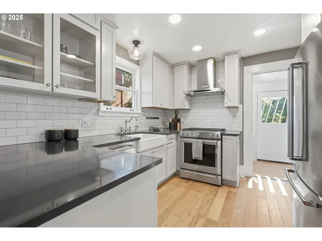 a kitchen with stainless steel appliances granite countertop a stove refrigerator sink and cabinets