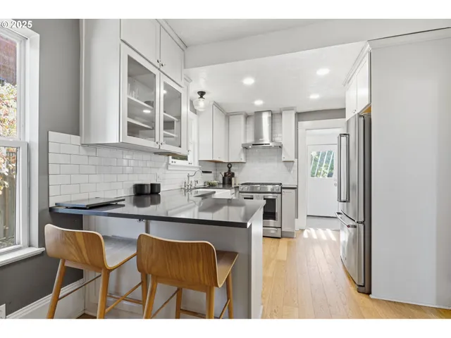 a kitchen with stainless steel appliances granite countertop a sink stove and cabinets