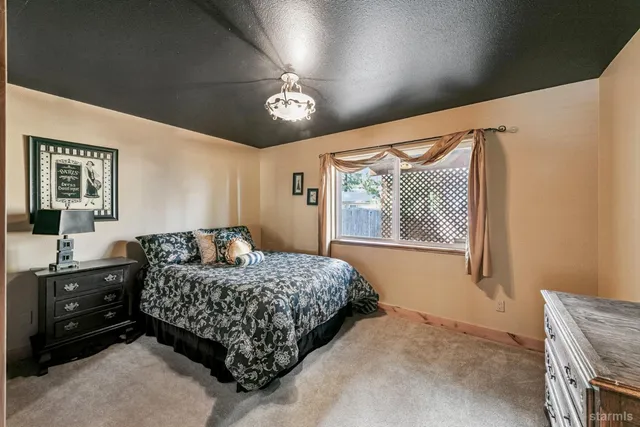 a bedroom with a bed dresser and a window