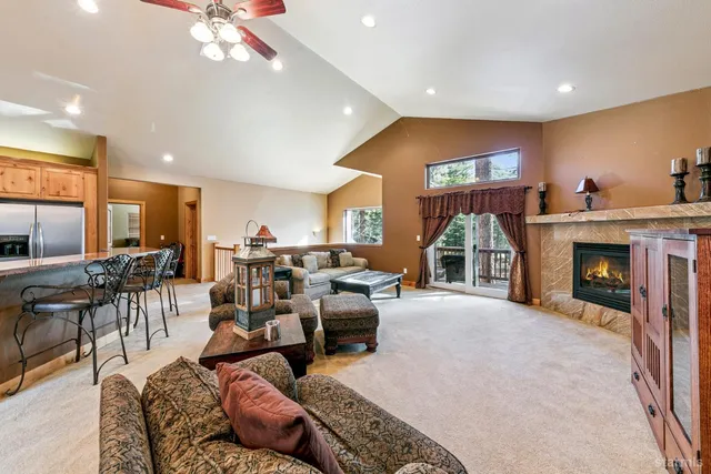 a living room with furniture a fireplace and a floor to ceiling window