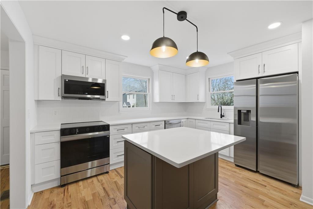 2415 Charleston Oaks Lane Decatur, GA 30030 - Photo 15 of 55 a kitchen with a center island and stainless steel appliances