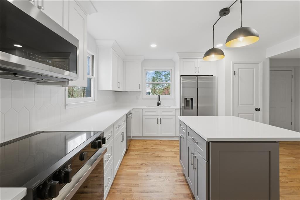 2415 Charleston Oaks Lane Decatur, GA 30030 - Photo 16 of 55 a kitchen that has a lot of white cabinets and stainless steel appliances
