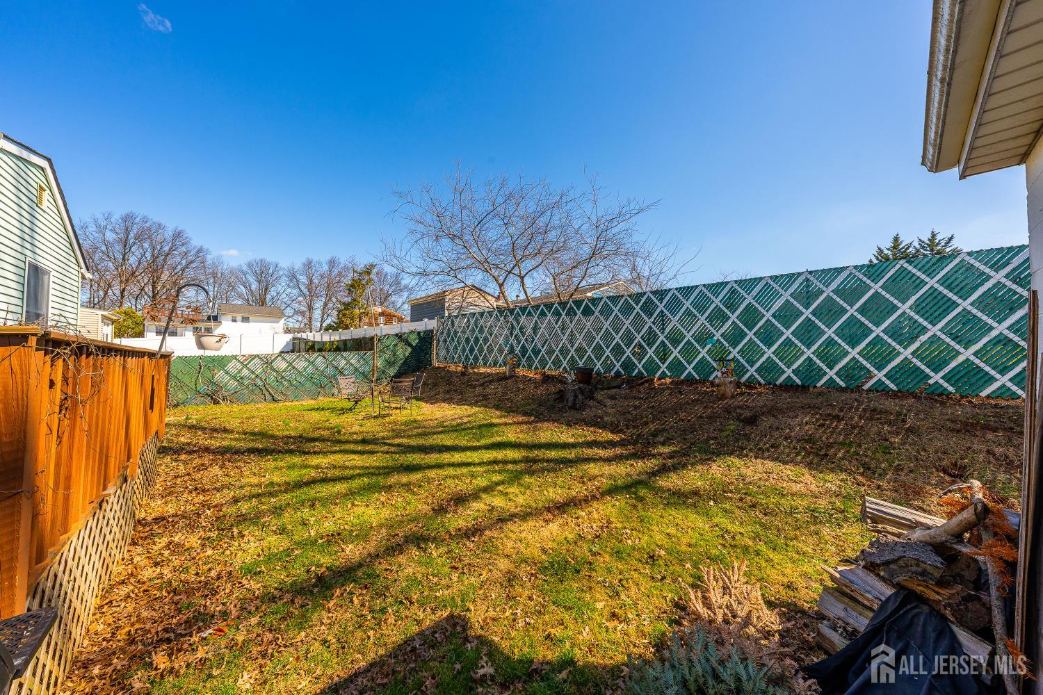 162 Rutherford Avenue Woodbridge, NJ 07095 - Photo 13 of 18 a view of a swimming pool with a lawn chairs and wooden fence