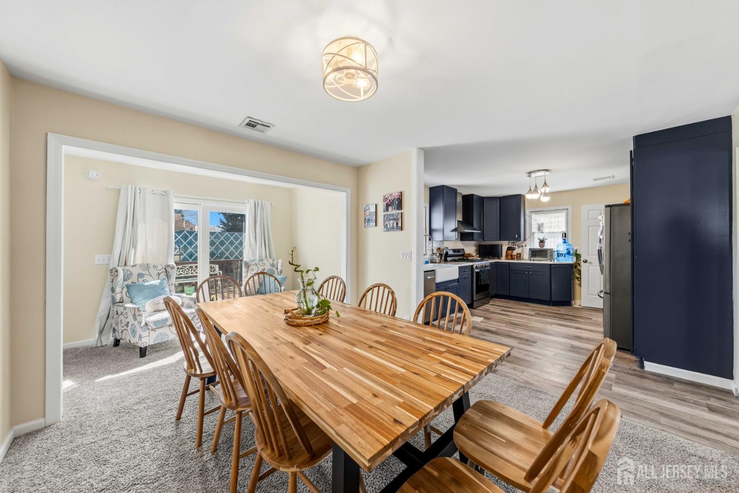 162 Rutherford Avenue Woodbridge, NJ 07095 - Photo 4 of 18 a dining room with wooden floor a chandelier a wooden table and chairs