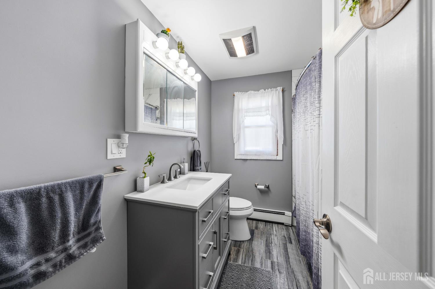162 Rutherford Avenue Woodbridge, NJ 07095 - Photo 9 of 18 a bathroom with a sink a toilet and a mirror