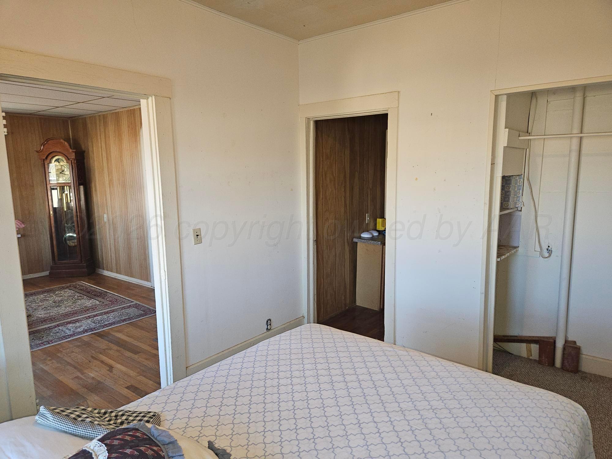 201 Oak Avenue Panhandle, TX 79068 - Photo 26 of 44 a bedroom with a bed and wooden floor