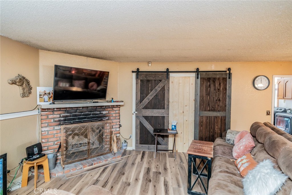 4637 Luna Road Phelan, CA 92371 - Photo 11 of 43 a living room with furniture a flat screen tv and a fireplace
