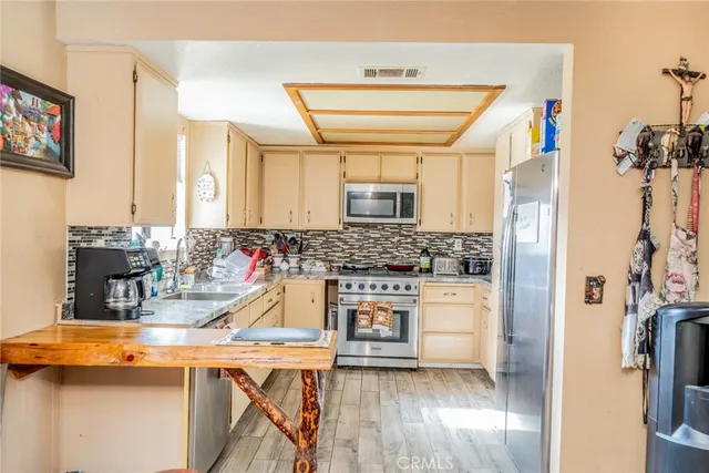 a kitchen with a refrigerator a sink dishwasher and a stove with wooden floor