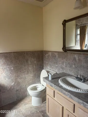 a bathroom with a toilet sink and mirror