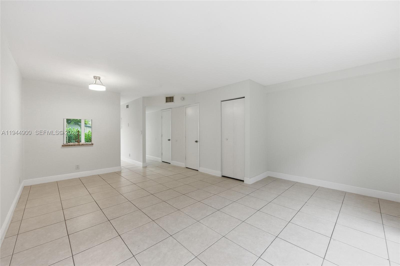 3003 Northwest 5th Terrace, Unit 2 Pompano Beach, FL 33064 - Photo 14 of 28 an empty room with white walls and tiles