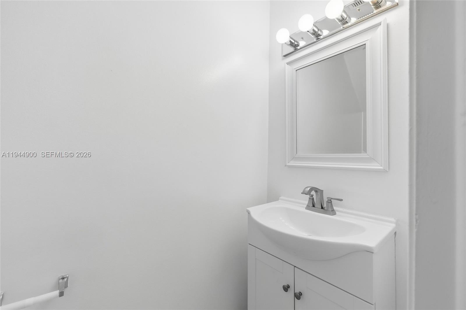 3003 Northwest 5th Terrace, Unit 2 Pompano Beach, FL 33064 - Photo 16 of 28 a bathroom with a sink a mirror and a vanity