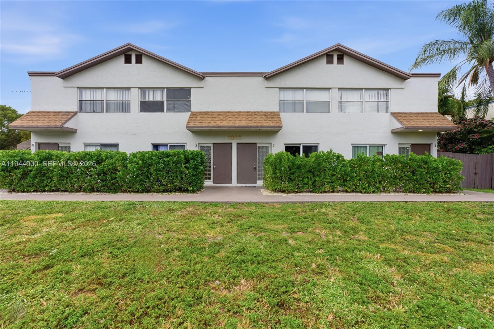 3003 Northwest 5th Terrace, Unit 2 Pompano Beach, FL 33064 - Photo 2 of 28 a front view of a house with a yard