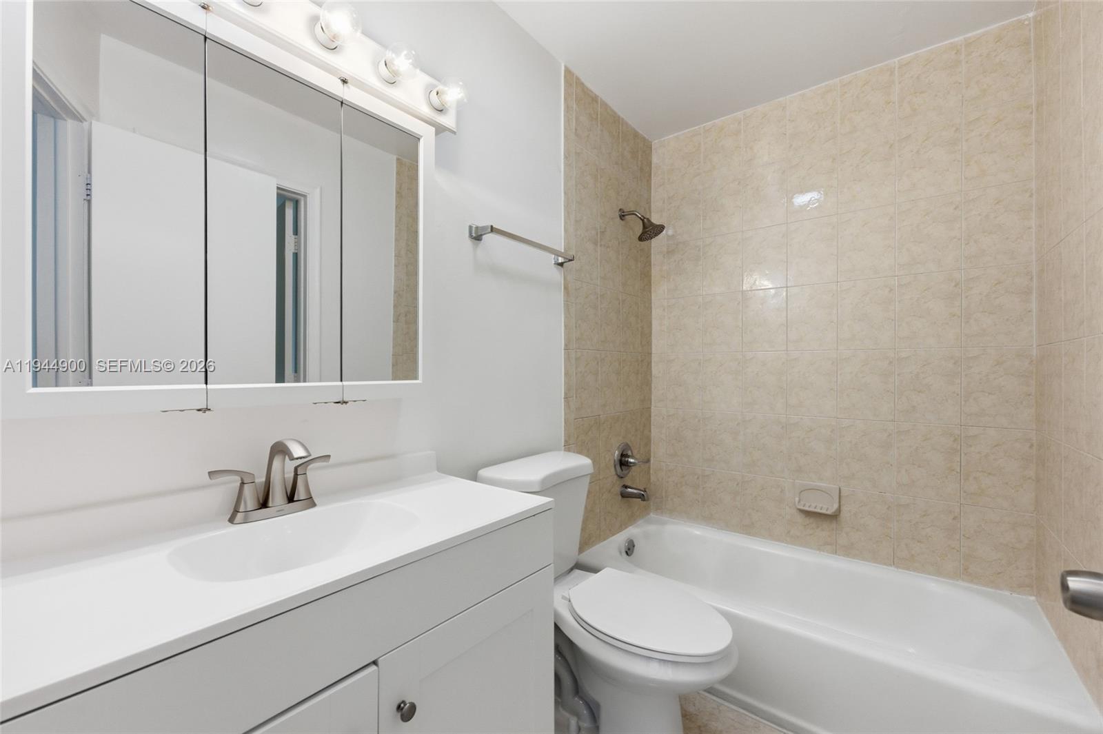 3003 Northwest 5th Terrace, Unit 2 Pompano Beach, FL 33064 - Photo 21 of 28 a bathroom with a sink toilet a mirror and shower