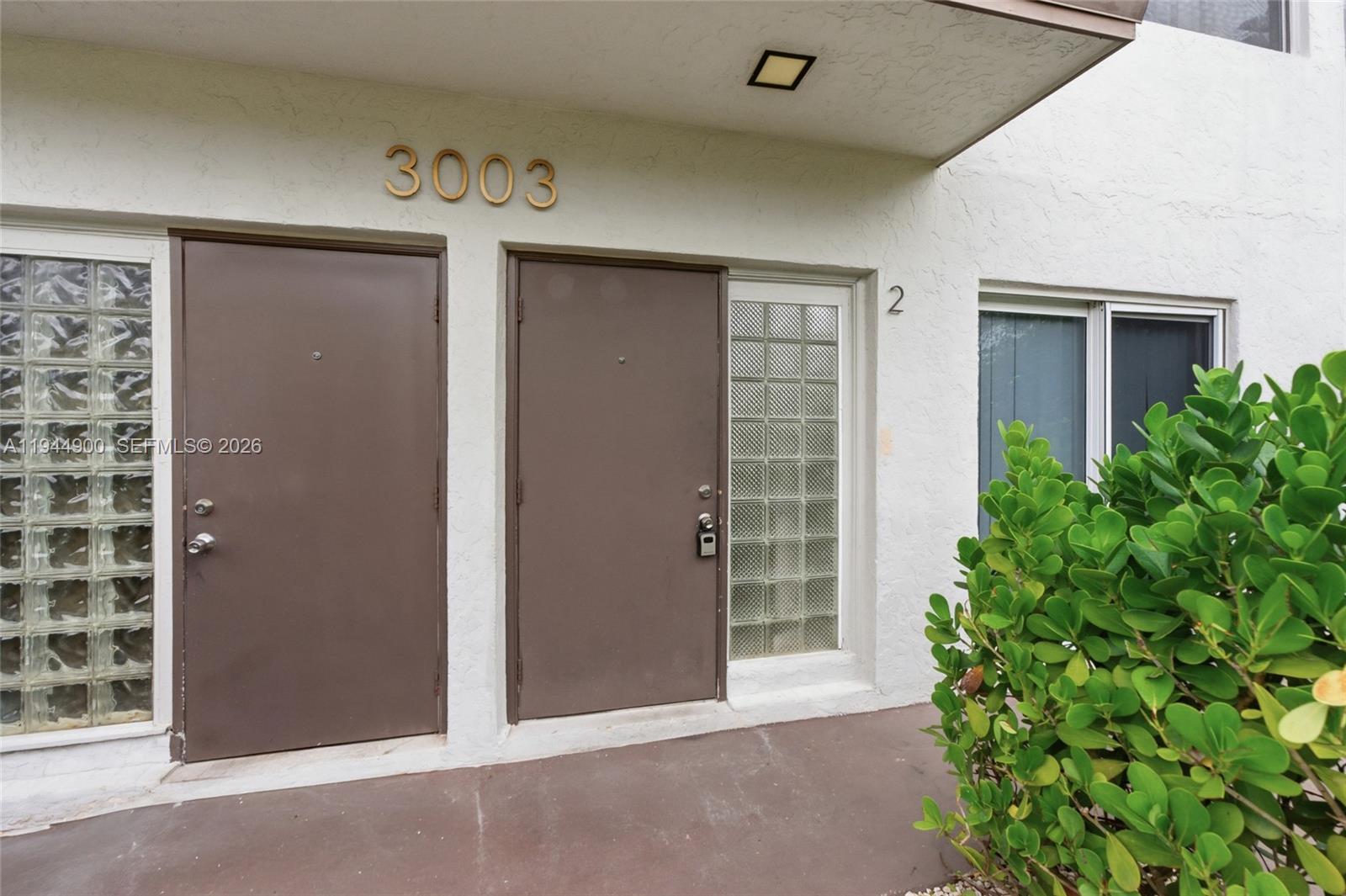3003 Northwest 5th Terrace, Unit 2 Pompano Beach, FL 33064 - Photo 27 of 28 an empty room with windows and plants