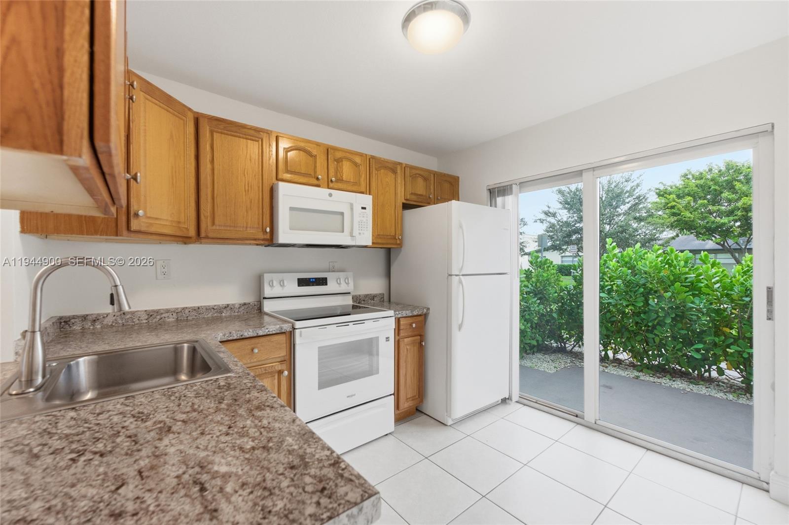 3003 Northwest 5th Terrace, Unit 2 Pompano Beach, FL 33064 - Photo 4 of 28 a kitchen with a refrigerator sink and cabinets