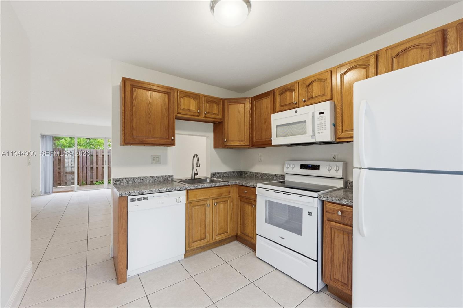 3003 Northwest 5th Terrace, Unit 2 Pompano Beach, FL 33064 - Photo 7 of 28 a kitchen with stainless steel appliances granite countertop a stove a sink and a refrigerator
