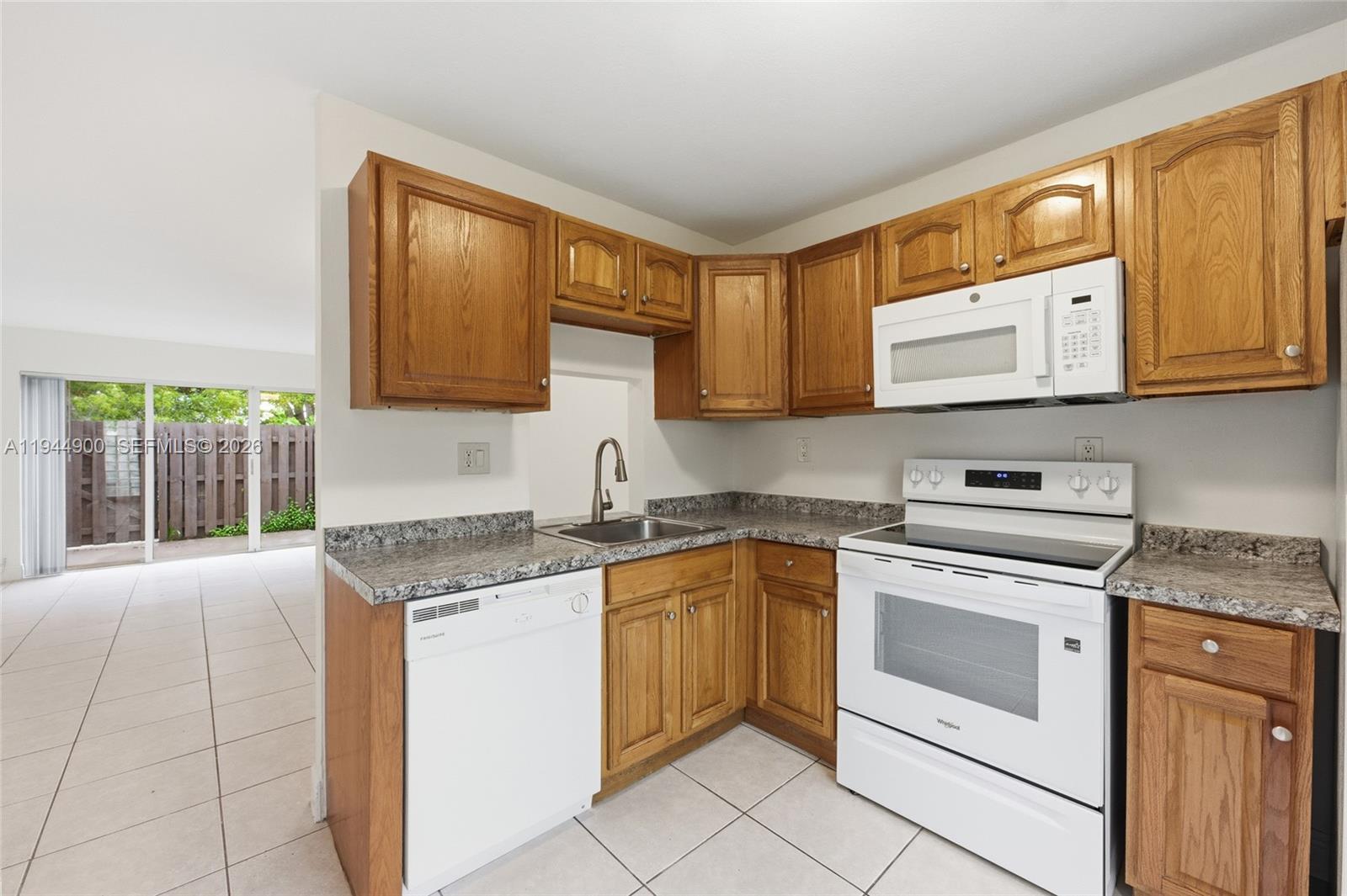 3003 Northwest 5th Terrace, Unit 2 Pompano Beach, FL 33064 - Photo 8 of 28 a kitchen with granite countertop cabinets stainless steel appliances and a sink