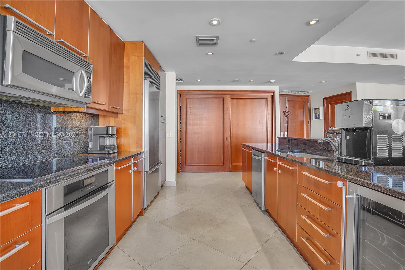 901 Brickell Key Boulevard, Unit 2807 Miami, FL 33131 - Photo 13 of 29 a large kitchen with stainless steel appliances granite countertop a large stove top oven a sink and dishwasher