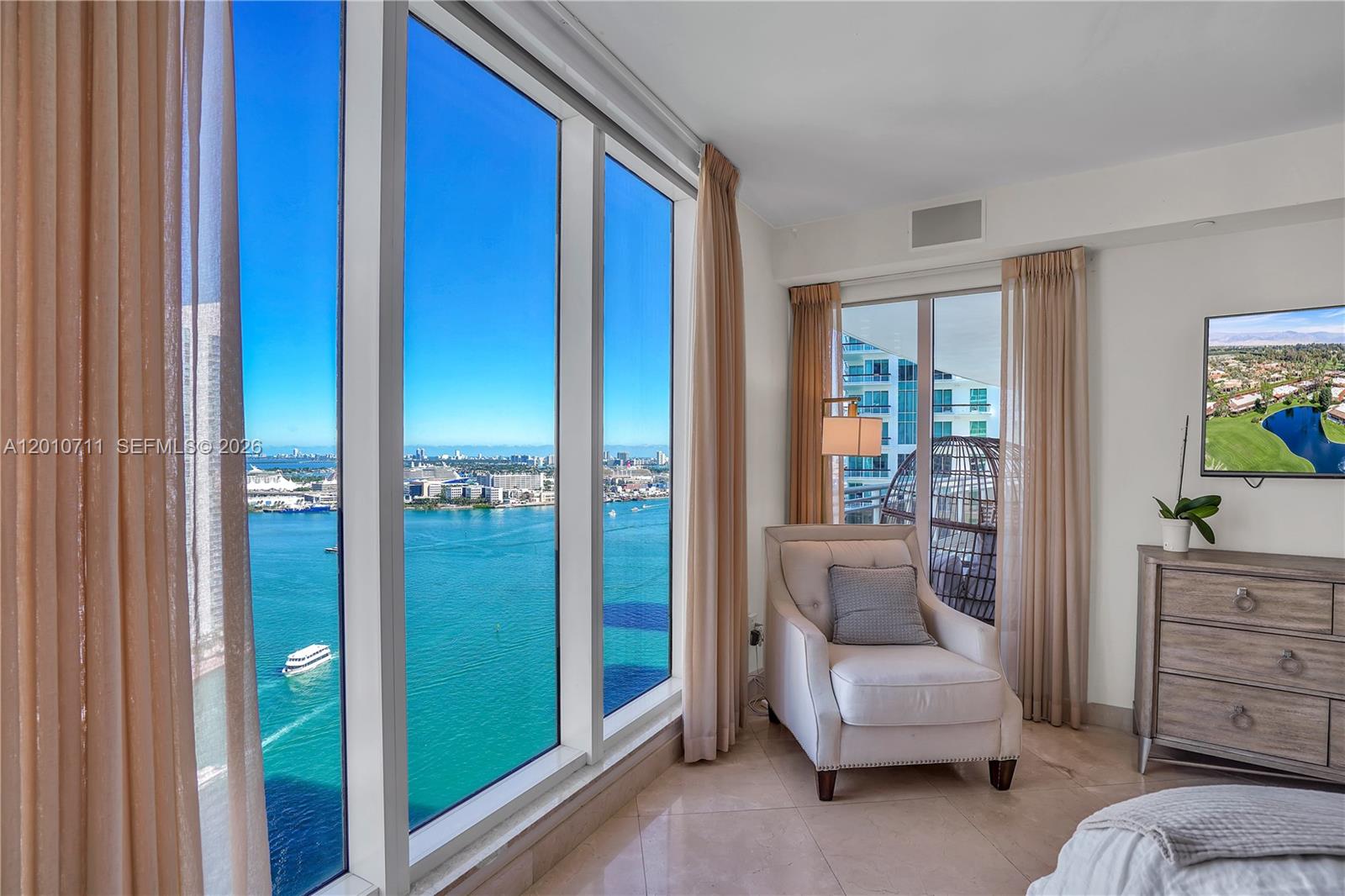 901 Brickell Key Boulevard, Unit 2807 Miami, FL 33131 - Photo 19 of 29 a living room with furniture and a window