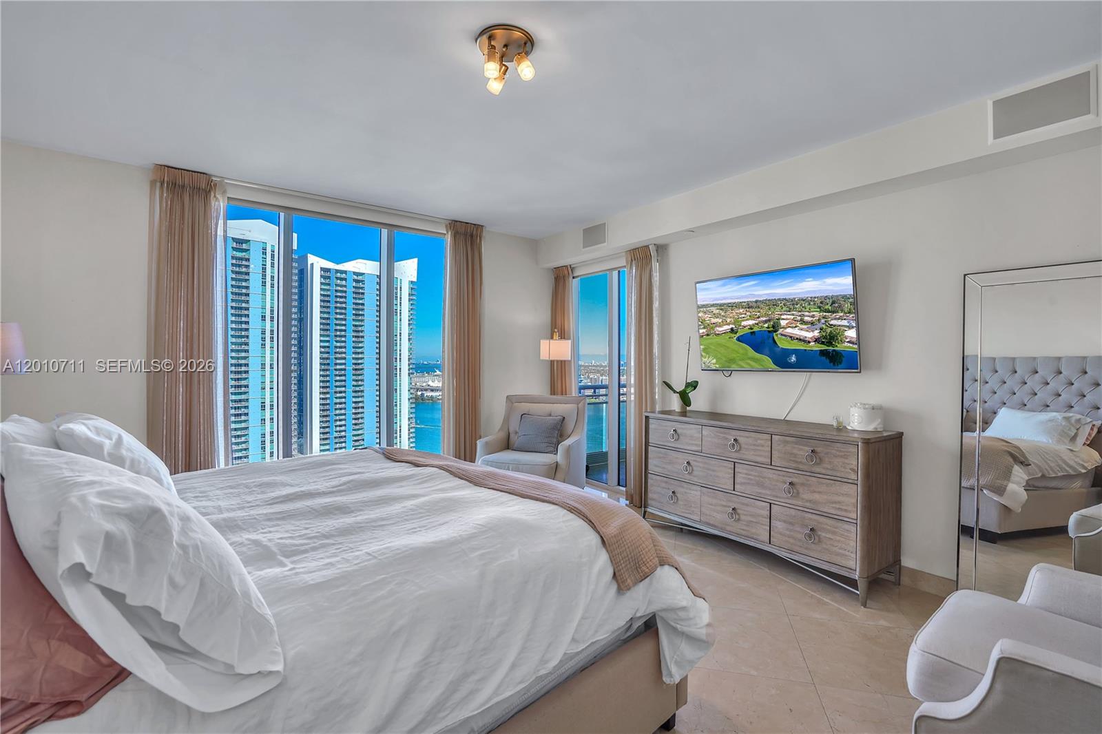 901 Brickell Key Boulevard, Unit 2807 Miami, FL 33131 - Photo 20 of 29 a bedroom with a bed and dresser