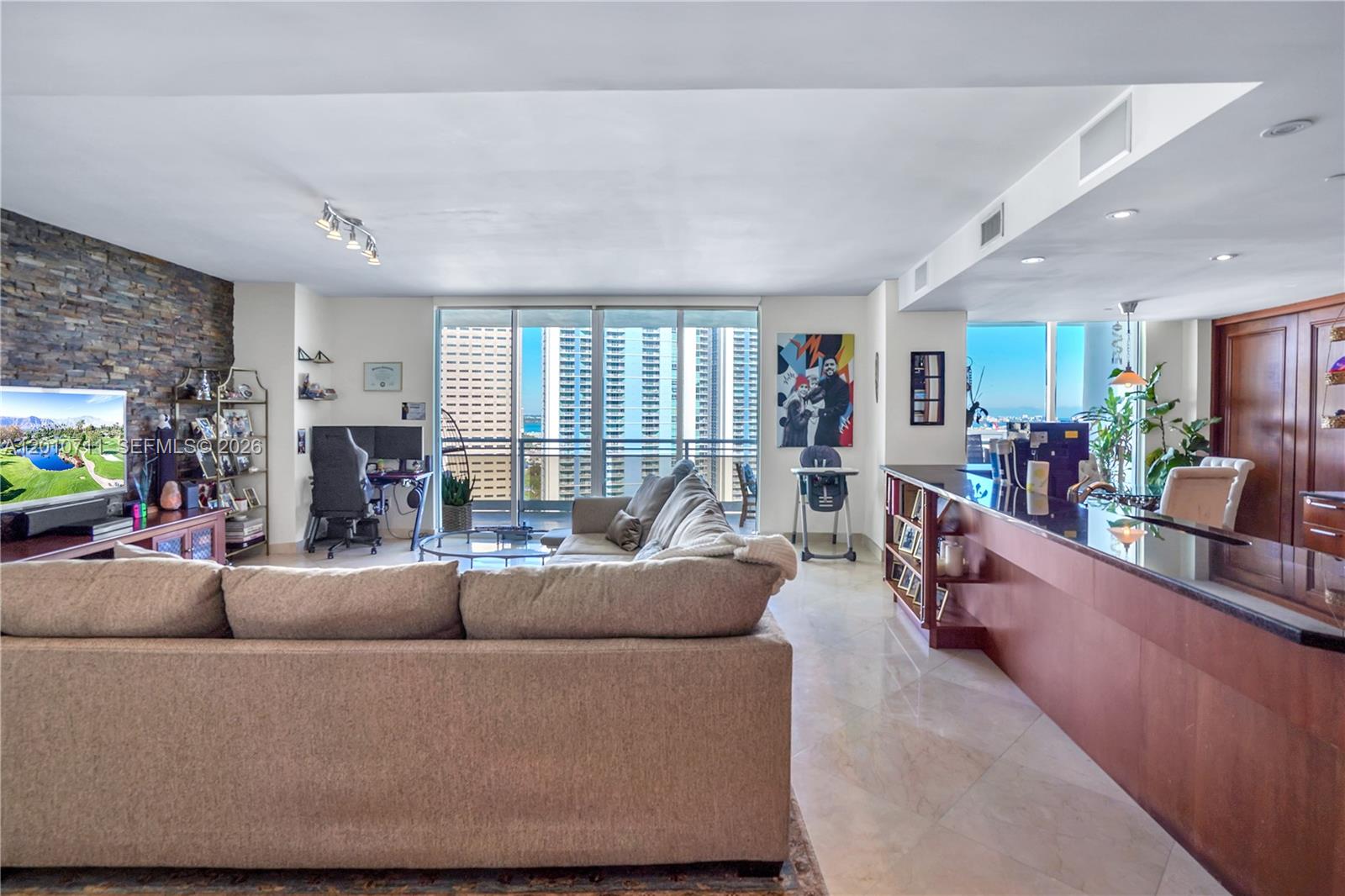 901 Brickell Key Boulevard, Unit 2807 Miami, FL 33131 - Photo 21 of 29 a living room with furniture and a flat screen tv