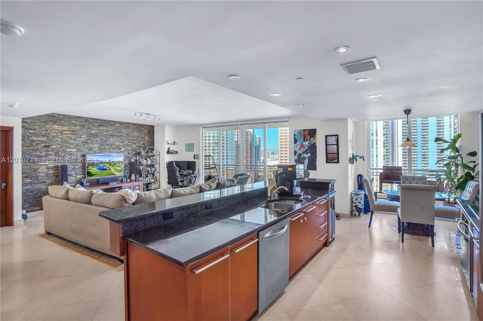 901 Brickell Key Boulevard, Unit 2807 Miami, FL 33131 - Photo 23 of 29 a large living room with stainless steel appliances kitchen island granite countertop a large counter top couches and couches