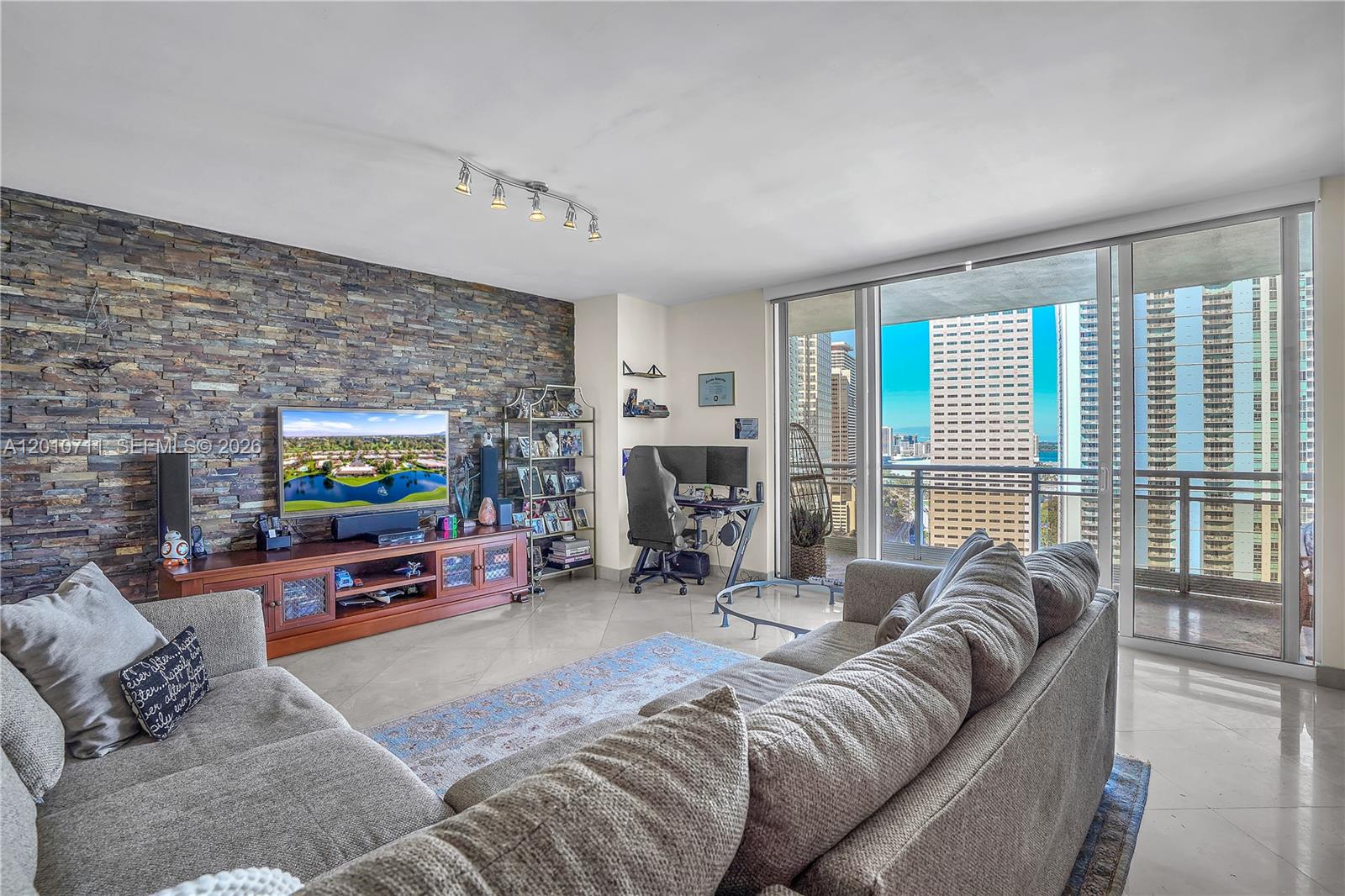 901 Brickell Key Boulevard, Unit 2807 Miami, FL 33131 - Photo 26 of 29 a living room with furniture a flat screen tv and a fireplace