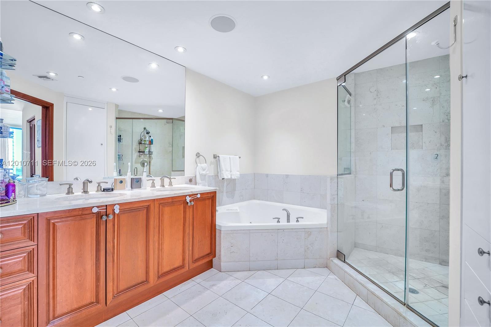 901 Brickell Key Boulevard, Unit 2807 Miami, FL 33131 - Photo 28 of 29 a bathroom with a tub a sink shower and mirror